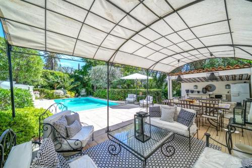 un salon extérieur avec une piscine et une terrasse dans l'établissement Cannes Luxury Rental - Belle epoque villa à louer proche centre Cannes, à Cannes