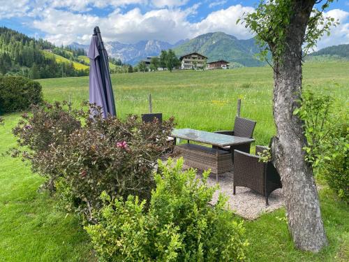 an umbrella and a table and chairs in a field at Haus Asslaber in Hochfilzen