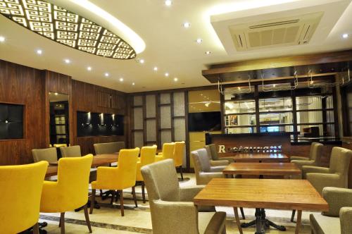 a restaurant with wooden tables and yellow chairs at Avin Hotel in İzmir