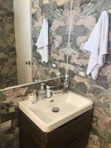 a bathroom with a sink and a mirror and towels at El Colorado 21, Hasparren in El Colorado