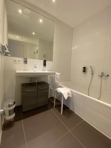 a bathroom with a tub and a sink and a mirror at grosszügiges Apartment mit Blick zur Frauenkirche in Dresden