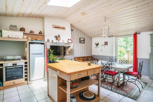 una cucina e una sala da pranzo con tavolo e sedie di Le Moulin de Pilet a Mortagne-sur-Sèvre
