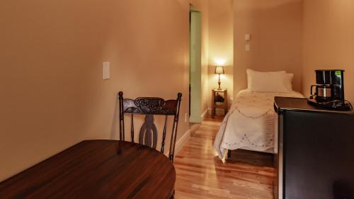 a bedroom with a bed and a chair in a room at Auberge Akamaraska in Kamouraska