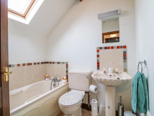 a bathroom with a tub and a toilet and a sink at The Cottage in Mapperley