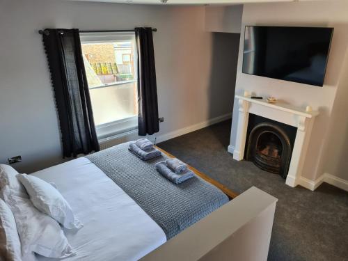 a bedroom with a bed and a tv and a fireplace at Tramway hotel in Pakefield