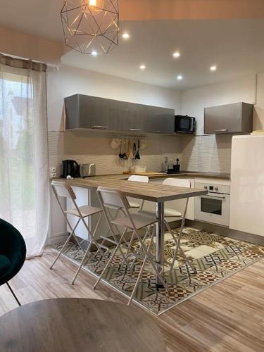 une cuisine avec une table et des chaises dans une pièce dans l'établissement Le Roosevelt - Proche centre - Parking privé, à Vannes