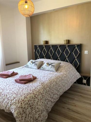- une chambre avec un lit et 2 chaussons roses dans l'établissement Le Roosevelt - Proche centre - Parking privé, à Vannes