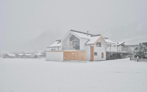 a house is covered in snow at Urban Mountain Splitlevel with Lake View in Maurach