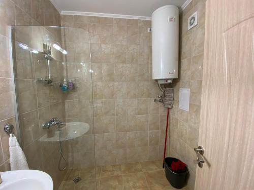 een badkamer met een douche, een wastafel en een toilet bij Apolon - beautiful apartments 200 m to the beach in Ravda