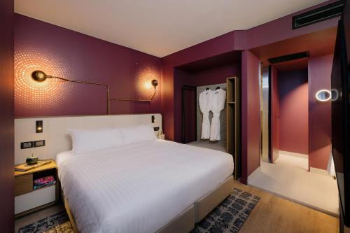 a bedroom with a large white bed and purple walls at Hotel Indigo Brisbane City Centre by IHG in Brisbane