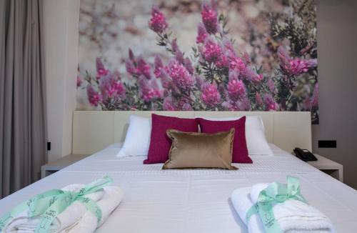 a bedroom with a white bed with purple flowers at Incognito Creta Luxury Suites and More in Kolymvari