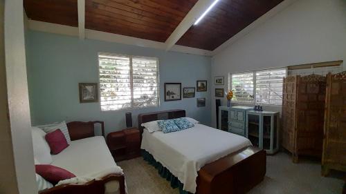 a bedroom with two beds and two windows at Neita's Nest in Kingston