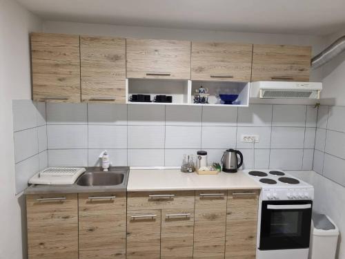 a small kitchen with a sink and a stove at Apartman Nermin in Mostar