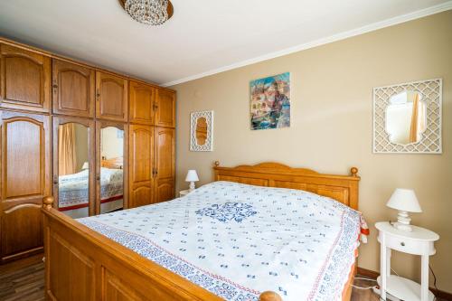 1 dormitorio con cama de madera y armarios de madera en Bella Luka Apartment, en Dubrovnik