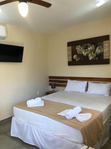 a bedroom with a large bed with towels on it at Pousada dos Pássaros in Quartéis