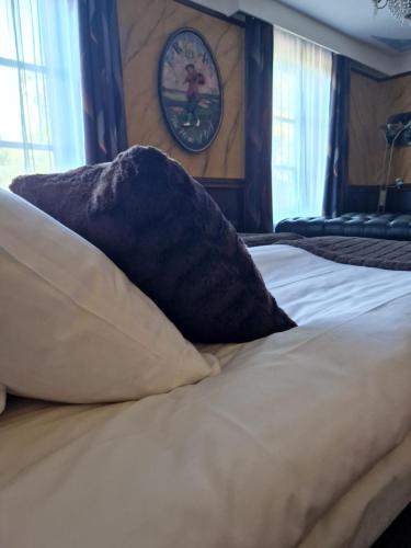 a bed with pillows and a clock on the wall at Best Western Motala Stadshotell in Motala