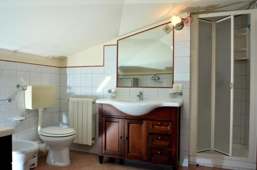 a bathroom with a sink and a toilet and a mirror at Sovareto Mare in Sciacca