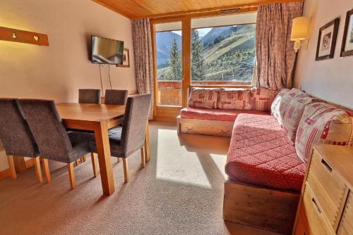 a living room with a table and a couch at Residence Plein Soleil in Méribel