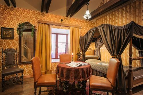 une chambre avec un lit, une table et des chaises dans l'établissement Börsen Apartment Suites, à Visby