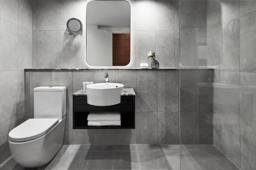 a bathroom with a sink and a toilet and a mirror at Crowne Plaza Sydney Airport by IHG in Sydney