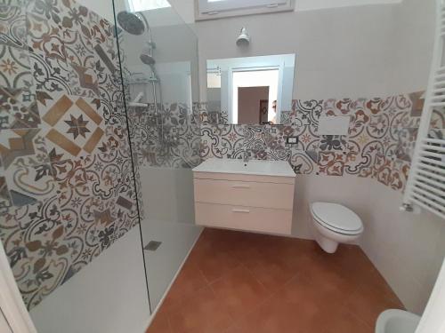 a bathroom with a toilet and a sink and a mirror at Villa GenVì - casa vacanza in Polignano a Mare