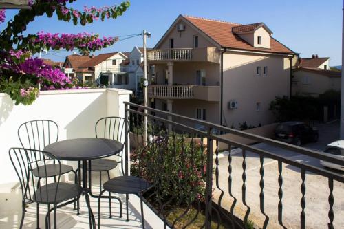 a balcony with a table and chairs and a building at Apartments PROVA **** in Tivat