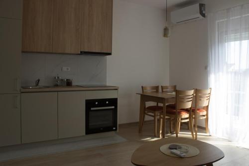 a kitchen with a table and chairs and a table and a tablektop at Apartments PROVA **** in Tivat