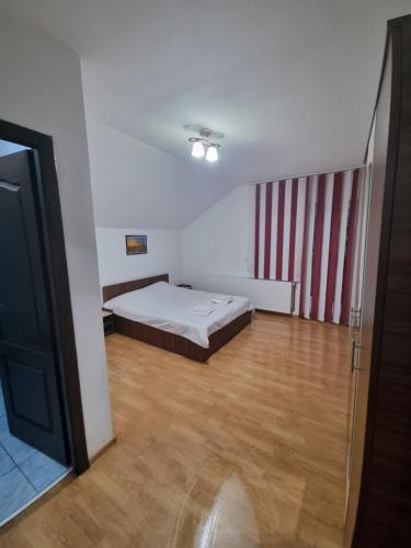 a bedroom with a bed and a wooden floor at Casa Alin Poiana Mărului in Poiana Mărului