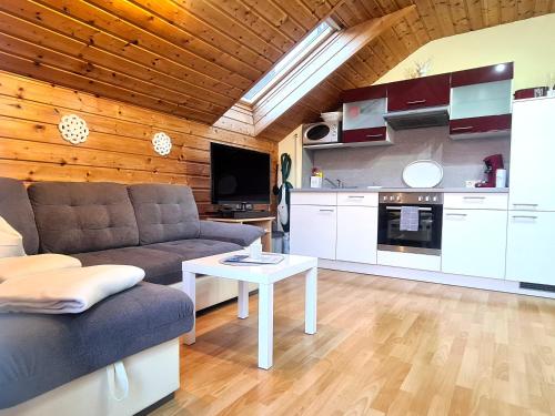 ein Wohnzimmer mit einem Sofa und einem Tisch in der Unterkunft Apartment Loindl in Unterach am Attersee