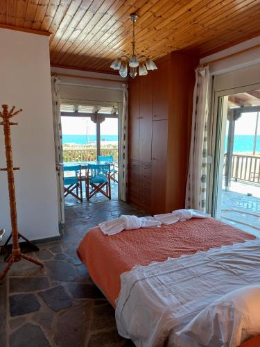 a bedroom with a bed and a view of the ocean at Villa Dimitra in Mourteri