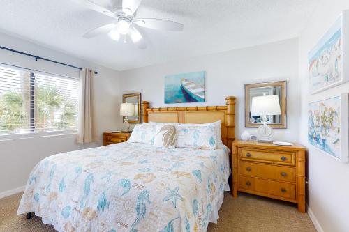 a bedroom with a bed and a ceiling fan at Beach Palms 108 in Clearwater Beach