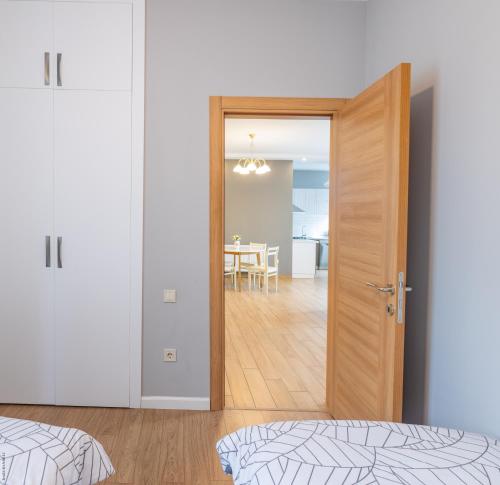 a bedroom with a door open to a dining room at Apartment By The Sheraton in Batumi
