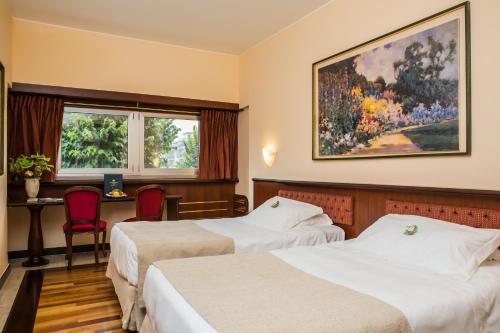 Un pat sau paturi într-o cameră la Santa Barbara Hotel