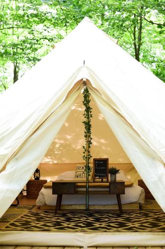 a white tent with a table in front of it at Grotto Getaway in Miller Lake