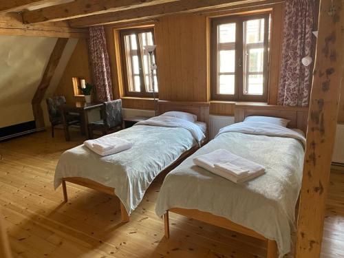 two twin beds in a room with windows at Kapteinis in Liepāja