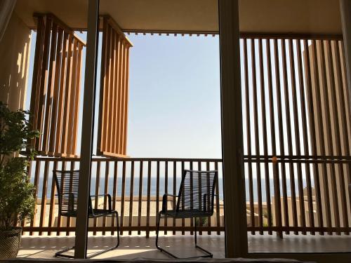 two chairs on a balcony with a view of the ocean at 3-bedroom beach villa with a pool and private sauna in Green Coast Palase in Palasë