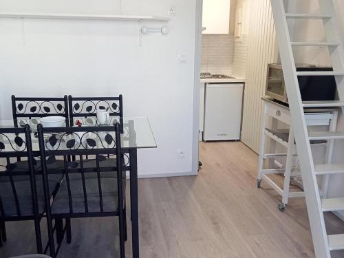 - une cuisine avec une table et un escalier dans une chambre dans l'établissement Studio mezzanine cosy à La Rochelle proche plage - FR-1-551-53, à La Rochelle