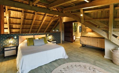 a bedroom with a large bed in a room with wooden ceilings at ChamGaia off-grid eco-villa in Chamarel