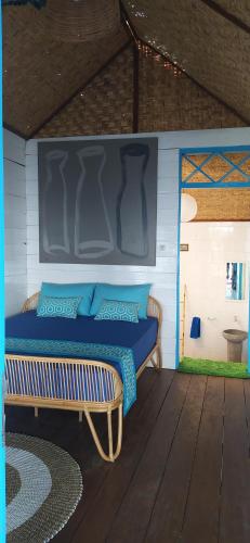 a bedroom with a blue bed and a bench at Moyo Island Resort in Moyo Island