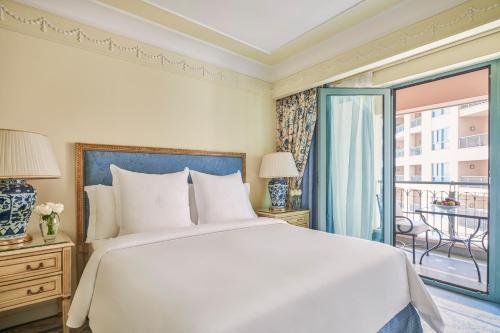 a bedroom with a large white bed and a balcony at Four Seasons Hotel Alexandria At San Stefano in Alexandria