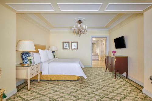 a bedroom with a white bed and a chandelier at Four Seasons Hotel Alexandria At San Stefano in Alexandria