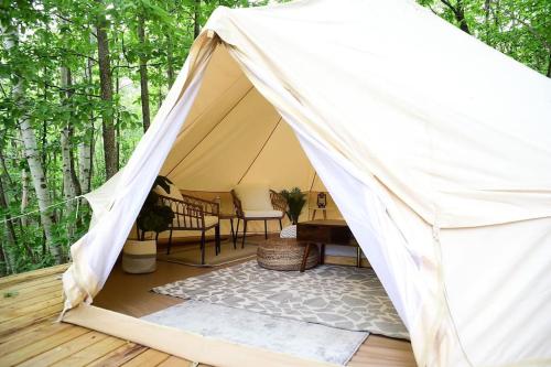 a tent on a deck with a table and chairs at Grotto Getaway in Miller Lake