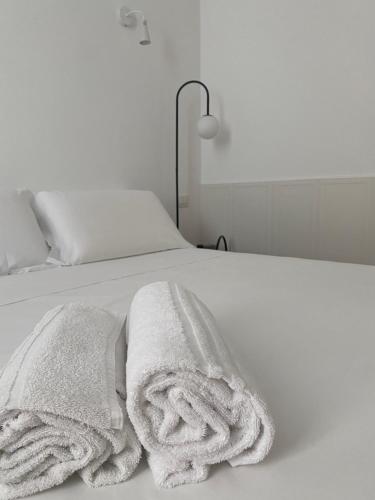 Una cama blanca con dos toallas blancas. en Ottaviano 9 Little Suite, en Roma