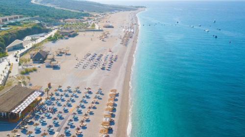 an aerial view of a beach with chairs and umbrellas at 3-bedroom beach villa with a pool and private sauna in Green Coast Palase in Palasë