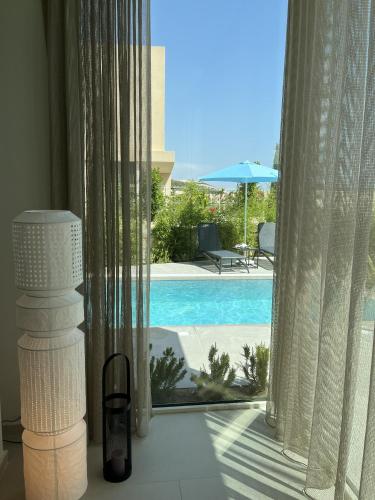 a room with a view of a swimming pool through a window at 3-bedroom beach villa with a pool and private sauna in Green Coast Palase in Palasë