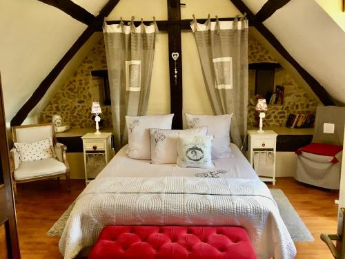 een slaapkamer met een groot bed met rode kussens bij CATHERINE & DOMINIQUE in Marigné-Laillé