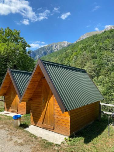 um pequeno edifício de madeira com um telhado de metal em Apartmani Sastavci em Tjentište