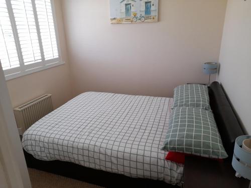 a small bedroom with a bed with a checkered blanket at Sundown 127 Sandown Bay Holiday Centre Generous Ferry Saving! in Sandown