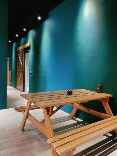 a wooden picnic table in front of a blue wall at Good hostel 好棧 Green Island in Green Island
