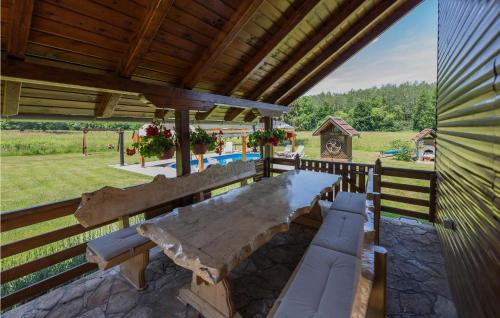 einen großen Holztisch und Bänke auf einer Terrasse in der Unterkunft 3 Bedroom Gorgeous Home In Cacinci in Čačinci